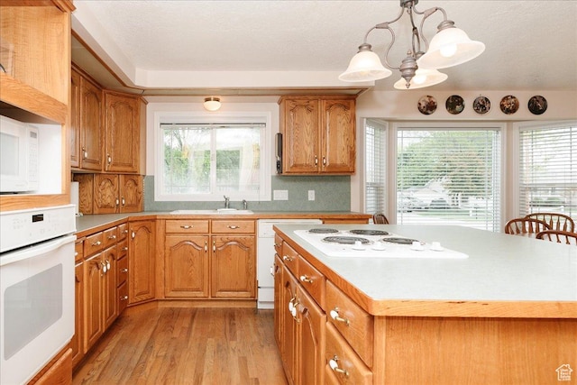 310 E Valley View Dr, Preston, ID 83263 - kitchen with white appliances, light wood-style flooring, brown cabinets, decorative backsplash, and light countertops