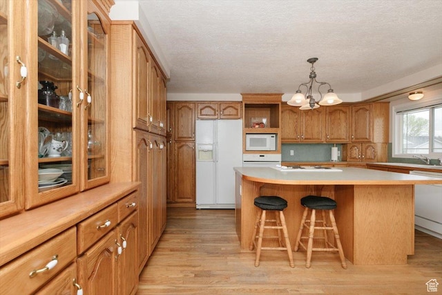 310 E Valley View Dr, Preston, ID 83263 - kitchen with white appliances, a chandelier, brown cabinetry, light wood finished floors, and a textured ceiling
