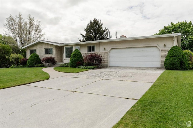 310 E Valley View Dr, Preston, ID 83263 - ranch-style home featuring a garage, concrete driveway, brick siding, a front yard, and stucco siding