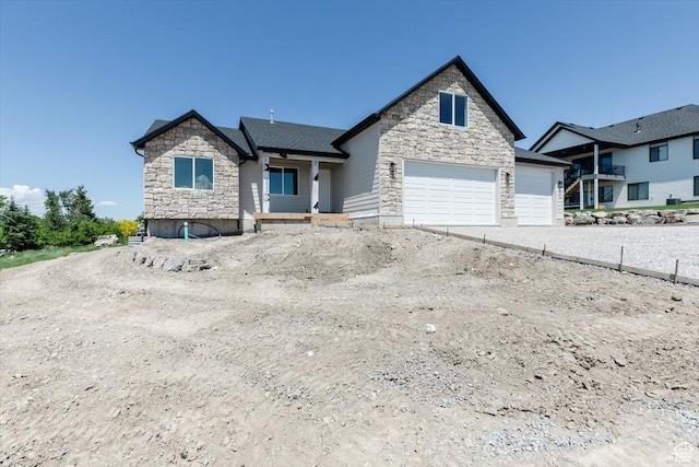 821 E 160 N, Hyde Park, UT 84318 - view of front facade featuring stone siding, a garage, and driveway