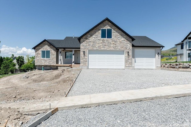 821 E 160 N, Hyde Park, UT 84318 - view of front facade with gravel driveway, stone siding, and a garage