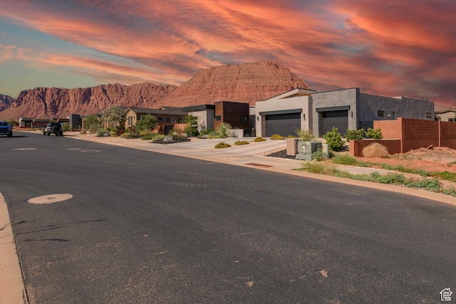 108 N Arrowhead Ln, Ivins, UT 84738 - modern home with a mountain view, concrete driveway, a garage, stucco siding, and a residential view