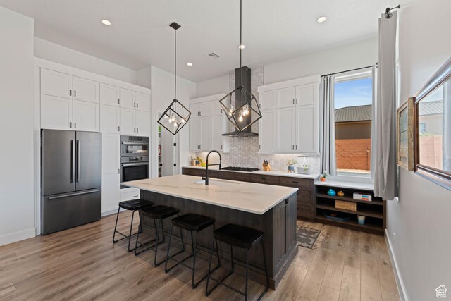 108 N Arrowhead Ln, Ivins, UT 84738 - kitchen with appliances with stainless steel finishes, wall chimney range hood, a sink, baseboards, and backsplash