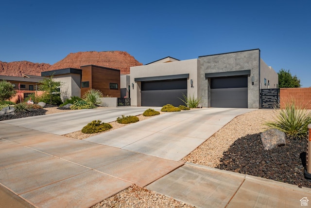 108 N Arrowhead Ln, Ivins, UT 84738 - contemporary house with stucco siding, concrete driveway, a garage, and a mountain view