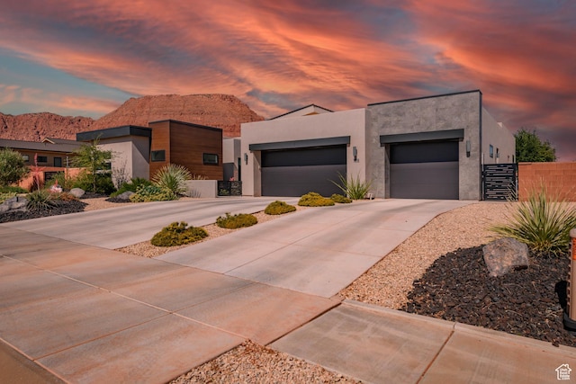 108 N Arrowhead Ln, Ivins, UT 84738 - modern home featuring stucco siding, concrete driveway, a mountain view, and an attached garage