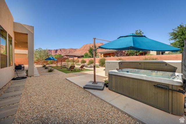 108 N Arrowhead Ln, Ivins, UT 84738 - fenced backyard featuring a hot tub, a mountain view, and a patio area