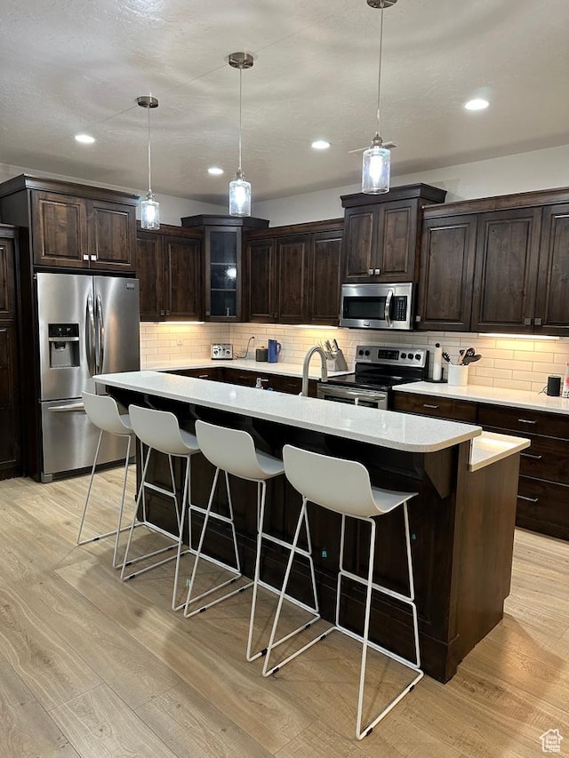 2786 S 3780 W, Hurricane, UT 84737 - kitchen featuring stainless steel appliances, a kitchen bar, light countertops, light wood finished floors, and recessed lighting