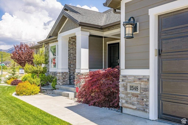 2548 E Ember Dr, Draper Ut Cnty, UT 84020 - doorway to property with stone siding, covered porch, and roof with shingles