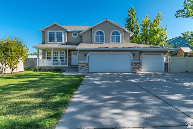 2761 W 9800 S, South Jordan, UT 84095 - traditional home featuring stucco siding, driveway, a porch, stone siding, and a gate