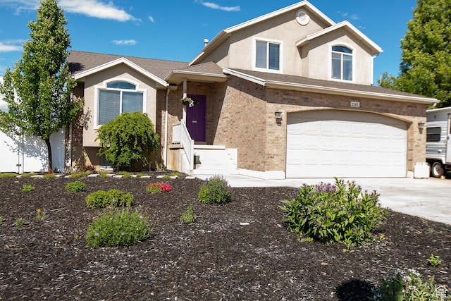 2182 W 1145 N, Clinton, UT 84015 - view of front of house featuring driveway, stucco siding, a garage, and brick siding