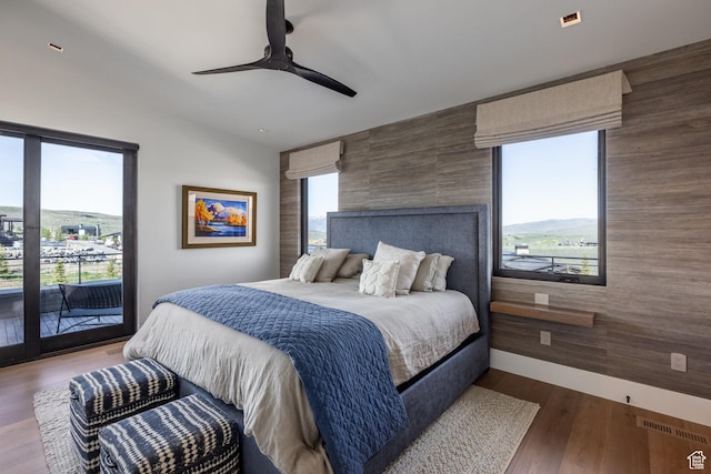 7744 E Moon Dance Cir, Kamas, UT 84036 - bedroom with access to exterior, an accent wall, wood finished floors, and a ceiling fan