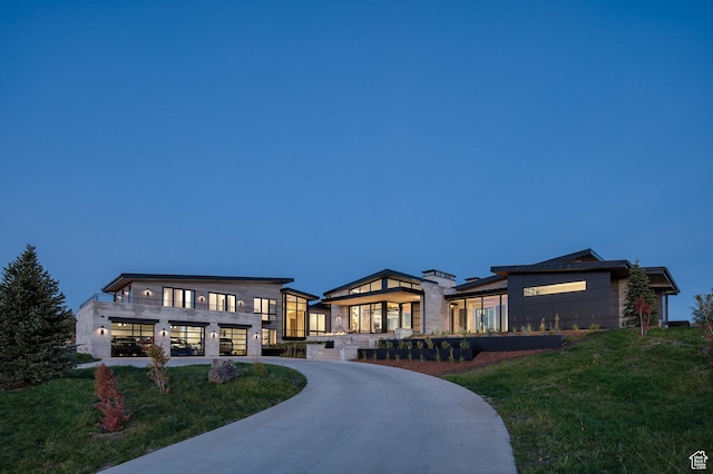 7744 E Moon Dance Cir, Kamas, UT 84036 - modern home featuring concrete driveway, an attached garage, a front yard, and stone siding