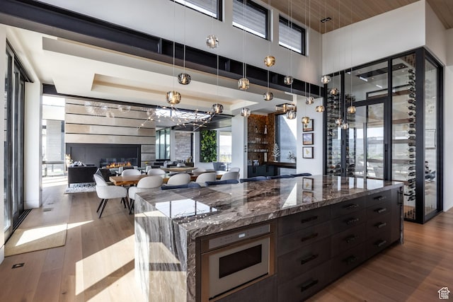 7744 E Moon Dance Cir, Kamas, UT 84036 - kitchen with wood finished floors, pendant lighting, open floor plan, and dark stone counters