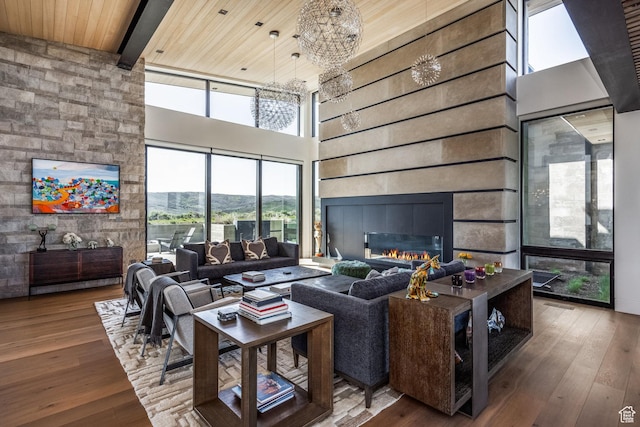7744 E Moon Dance Cir, Kamas, UT 84036 - living room with a towering ceiling, healthy amount of natural light, wood-type flooring, a glass covered fireplace, and wooden ceiling with exposed beams
