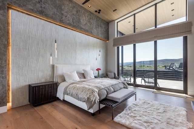 7744 E Moon Dance Cir, Kamas, UT 84036 - bedroom featuring a towering ceiling, access to outside, and wood finished floors