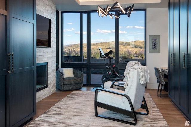 7744 E Moon Dance Cir, Kamas, UT 84036 - living area featuring expansive windows, a chandelier, wood finished floors, and an outdoor stone fireplace