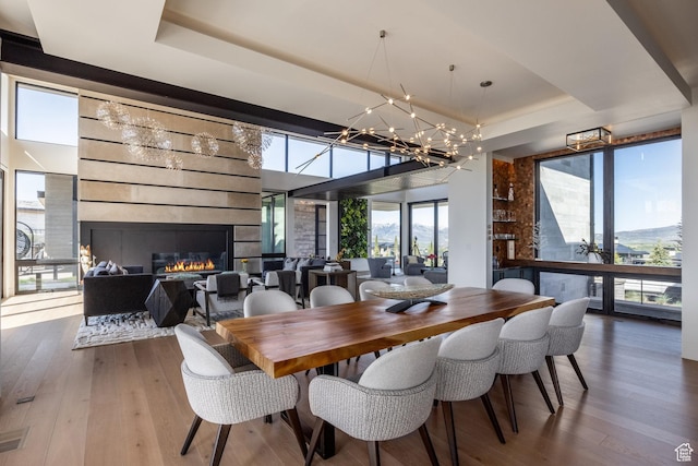 7744 E Moon Dance Cir, Kamas, UT 84036 - dining room with a tray ceiling, plenty of natural light, a chandelier, and wood finished floors