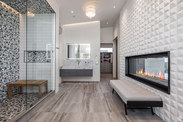 7744 E Moon Dance Cir, Kamas, UT 84036 - full bathroom with a stall shower, vanity, a multi sided fireplace, and wood finished floors