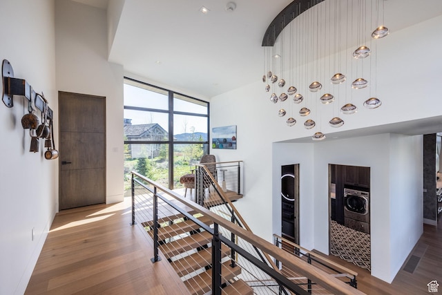7744 E Moon Dance Cir, Kamas, UT 84036 - staircase with expansive windows, wood finished floors, a towering ceiling, and washer / dryer