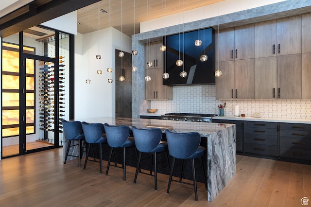 7744 E Moon Dance Cir, Kamas, UT 84036 - kitchen with decorative backsplash, light wood-style floors, and a kitchen breakfast bar
