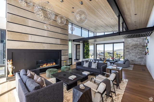 7744 E Moon Dance Cir, Kamas, UT 84036 - living room featuring wooden ceiling, a glass covered fireplace, wood finished floors, and a chandelier