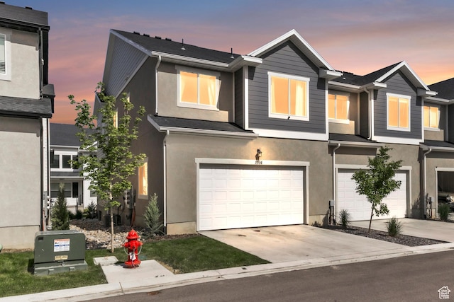 1994 N 3900 W Unit 217, Lehi, UT 84043 - view of front of property with stucco siding, an attached garage, driveway, and cooling unit