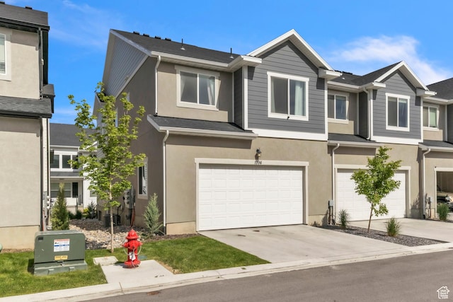 1994 N 3900 W Unit 217, Lehi, UT 84043 - view of front facade featuring a garage, stucco siding, driveway, and cooling unit