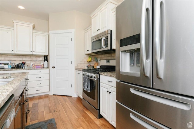 225 E 620 S, Smithfield, UT 84335 - kitchen with stainless steel appliances, light wood finished floors, white cabinetry, backsplash, and recessed lighting
