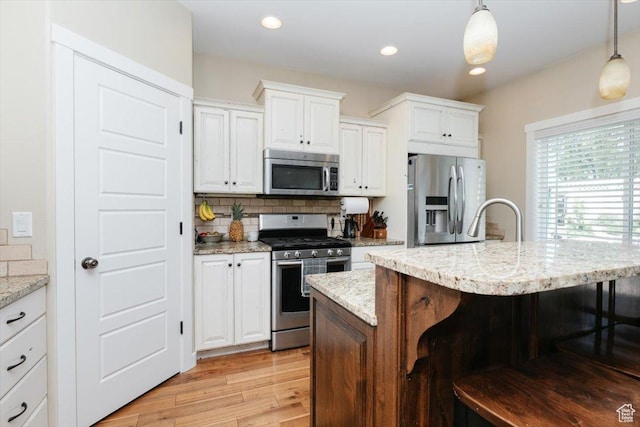 225 E 620 S, Smithfield, UT 84335 - kitchen featuring appliances with stainless steel finishes, a kitchen bar, white cabinets, hanging light fixtures, and recessed lighting