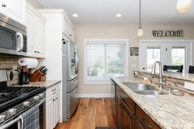 225 E 620 S, Smithfield, UT 84335 - kitchen featuring appliances with stainless steel finishes, a sink, light wood-style flooring, baseboards, and backsplash