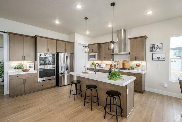1104 N Windflower Ln Unit 127, Grantsville, UT 84029 - kitchen featuring wall chimney range hood, appliances with stainless steel finishes, a kitchen breakfast bar, light wood-style flooring, and recessed lighting