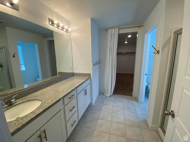 2132 N Elderberry Dr W, Saratoga Springs, UT 84045 - bathroom with toilet, double vanity, tile patterned floors, a walk in closet, and baseboards