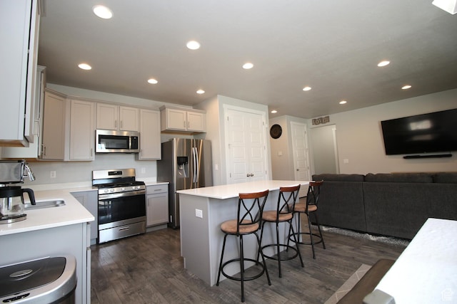 1457 W 400 S, Syracuse, UT 84075 - kitchen with stainless steel appliances, dark wood-style flooring, a breakfast bar area, recessed lighting, and a kitchen island