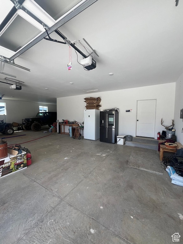 19722 Elkhorn Cir, Birdseye, UT 84629 - garage with a garage door opener, freestanding refrigerator, and refrigerator with ice dispenser