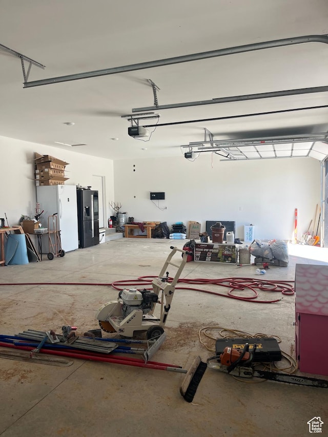 19722 Elkhorn Cir, Birdseye, UT 84629 - garage with stainless steel refrigerator with ice dispenser and a garage door opener