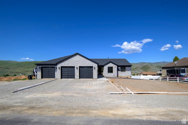 19722 Elkhorn Cir, Birdseye, UT 84629 - view of front of property featuring a mountain view, stone siding, and a garage