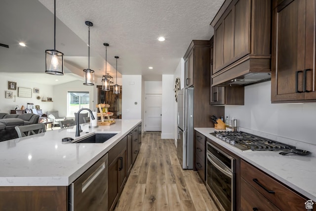 19722 Elkhorn Cir, Birdseye, UT 84629 - kitchen with appliances with stainless steel finishes, a sink, open floor plan, light wood finished floors, and a center island with sink