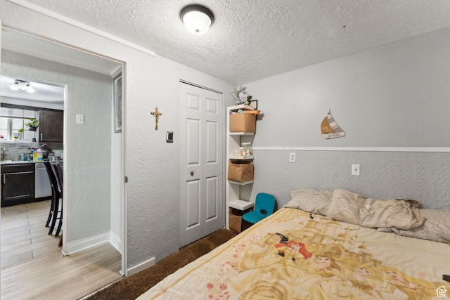 2120 Pingree Ave, Ogden, UT 84401 - bedroom with a textured ceiling, a closet, a textured wall, light wood finished floors, and baseboards