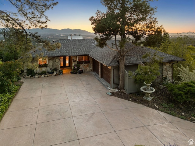4774 S Oak Terrace Dr, Millcreek, UT 84124 - view of front of house with stone siding, driveway, a mountain view, and a shingled roof