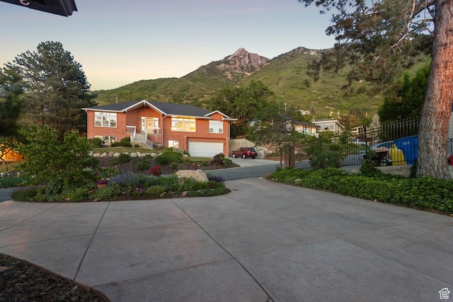 4774 S Oak Terrace Dr, Millcreek, UT 84124 - bi-level home with concrete driveway, a mountain view, and an attached garage