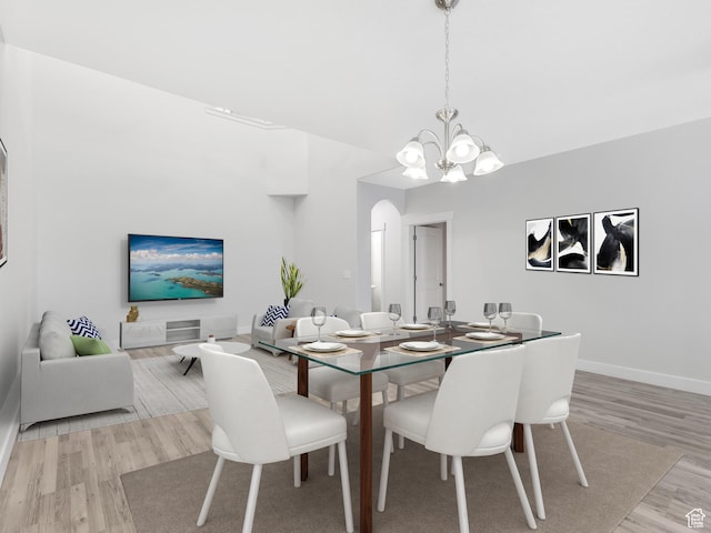 3964 W Hardman Way, Lehi, UT 84043 - dining area featuring light wood-style floors, a chandelier, baseboards, and arched walkways