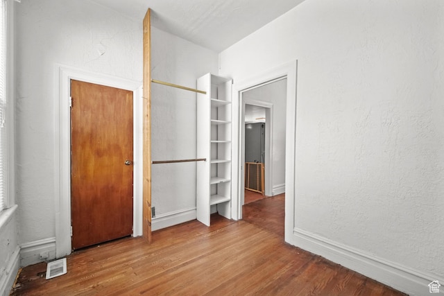 665 S Emery St W, Salt Lake City, UT 84104 - unfurnished bedroom featuring wood finished floors, baseboards, and a textured wall