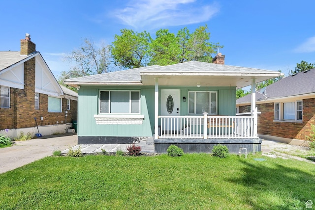 2883 S Brinker Ave E, Ogden, UT 84403 - bungalow featuring covered porch, a front yard, a chimney, and roof with shingles