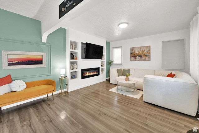 2883 S Brinker Ave E, Ogden, UT 84403 - living area with a glass covered fireplace, a textured ceiling, wood finished floors, built in features, and baseboards