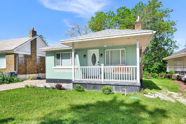 2883 S Brinker Ave E, Ogden, UT 84403 - bungalow-style home featuring a porch, a chimney, and a front lawn