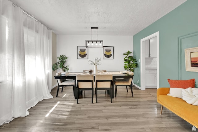 2883 S Brinker Ave E, Ogden, UT 84403 - dining space with a textured ceiling, light wood-style flooring, and baseboards
