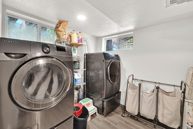 2883 S Brinker Ave E, Ogden, UT 84403 - laundry area with wood finished floors, washing machine and dryer, a textured ceiling, healthy amount of natural light, and baseboards