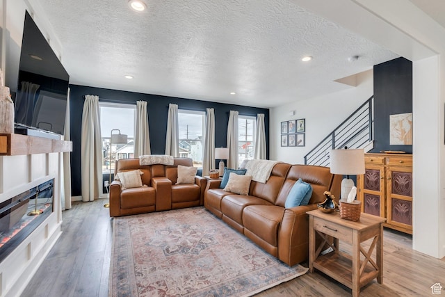 6439 W S Jordan Pkwy, South Jordan, UT 84009 - living room with a textured ceiling, light wood-style flooring, plenty of natural light, stairs, and recessed lighting