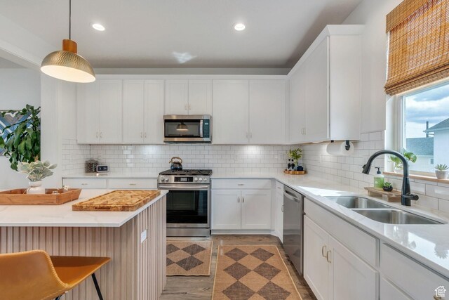 6439 W S Jordan Pkwy, South Jordan, UT 84009 - kitchen with appliances with stainless steel finishes, a sink, white cabinetry, backsplash, and recessed lighting
