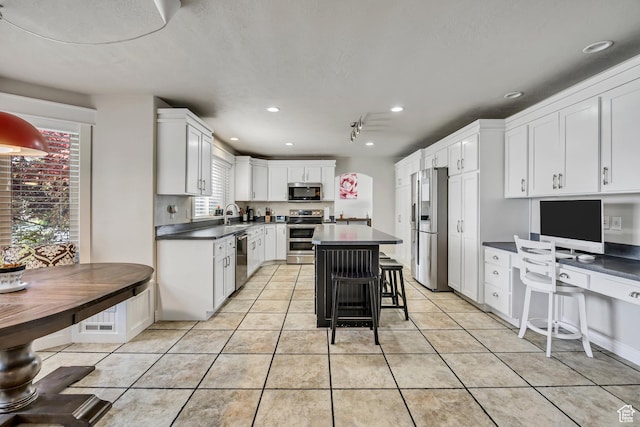 1162 E 1180 N, American Fork, UT 84003 - kitchen with appliances with stainless steel finishes, dark countertops, white cabinets, a center island, and light tile patterned floors